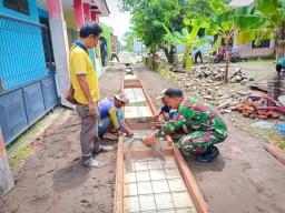 Babinsa Ramil 0816/13 bersama warga kerja bakti pembuatan saluran air