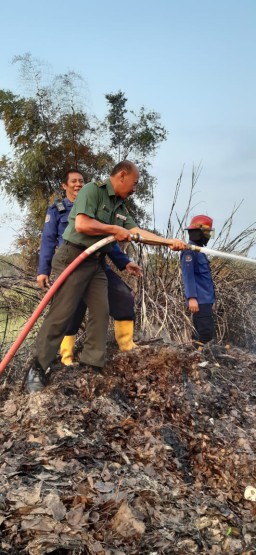Babinsa Koramil 0816/01 Pelda Sutikno membantu memadamkan kebakaran yang terjadi di Desa Bluru Kidul