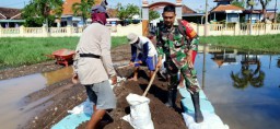Babinsa bersama masyarakat melaksanakan pengurukan halaman sekolah yg terdampak banjir