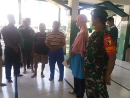 Babinsa koramil 0816/01 Peltu Dominggus membantu pelaksanaan penyemprotan disinvektan di Wilayah binaannya.