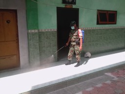 Sertu Dampar Hariyono melaksanakan penyemprotan desinfektan bersama tim dari Puskesmas Prambon