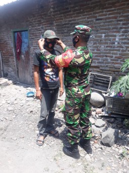 HUT TNI ke 75, Babinsa Prambon berikan paket sembako dan masker pada warga