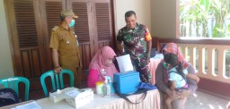 Babinsa &amp; Bhabinkamtibmas Mendampingi Petugas Kesehatan Melaksanakan Imunisasi Anak Nasional BIAN di Balai Desa Kebaron