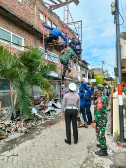 Babinsa 0816/01 membantu warga terdampak hujan dan angin kencang di kelurahan sekardangan.