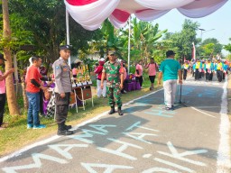 Babinsa Koramil 0816/11 Tarik Monitoring dan Pengamanan Lomba Gerak Jalan di Desa Binaan