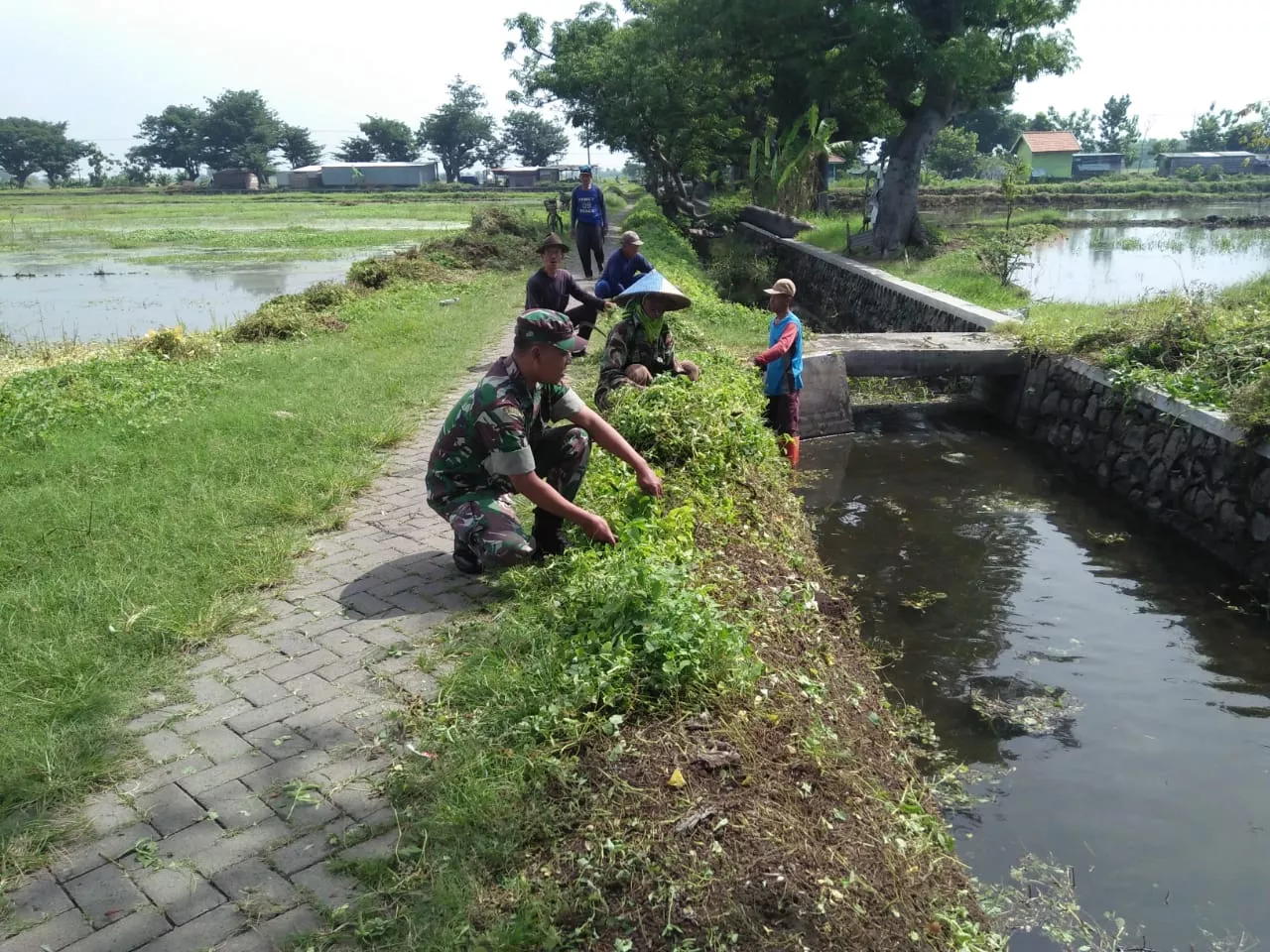 Babinsa 0816/08 bersama masyarakat melaksanakan kerja bakti dengan sasaran irigasi/saluran air