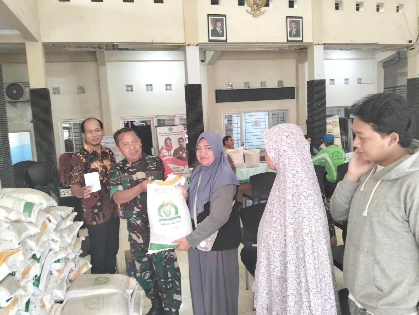Babinsa Koramil 0816/01 Sidoarjo bantu penyaluran beras Bansos di kelurahan Pucanganom Sidoarjo.